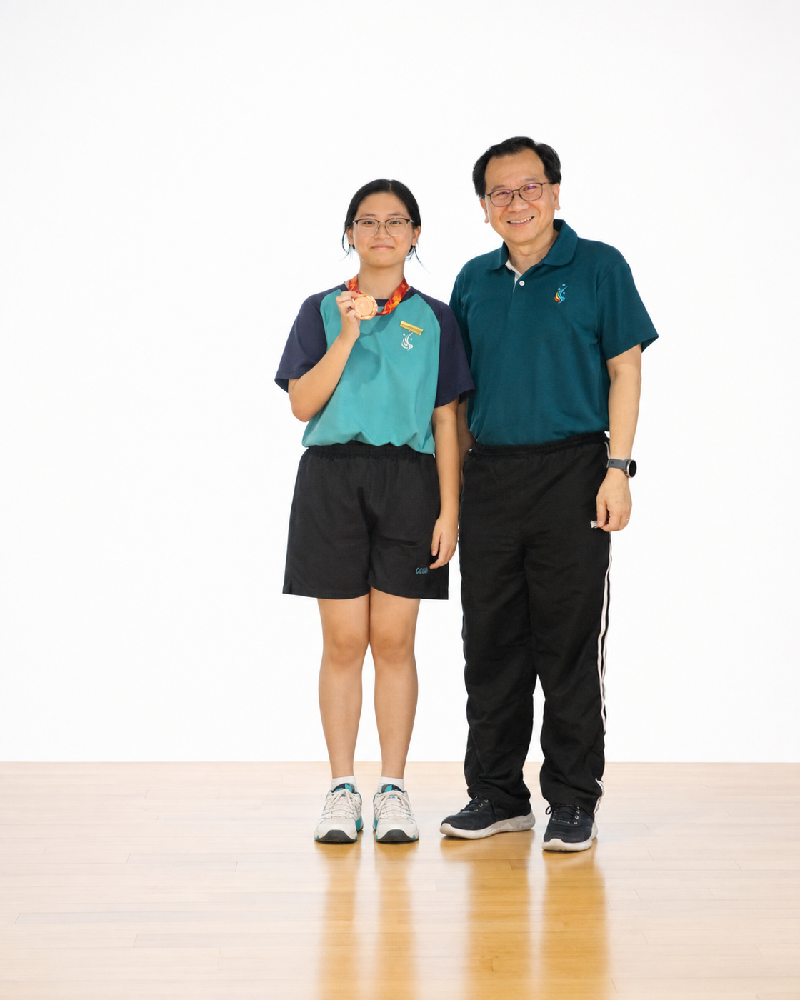 girl with medal stands on stage with principal